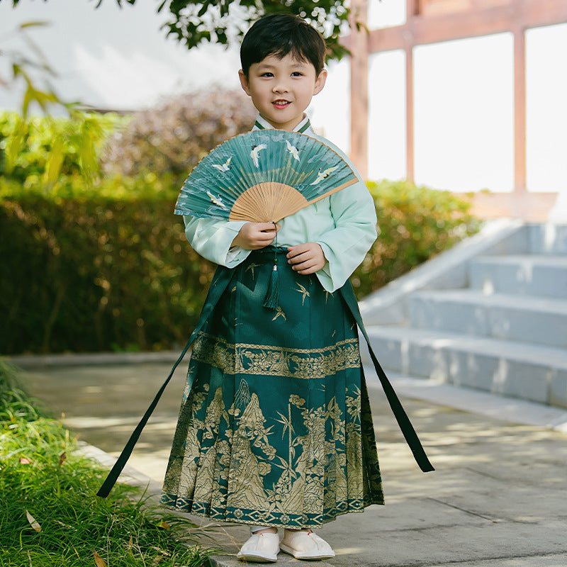 A boy wears a dark green mamianqun skirt with golden embroidery patterns to experience Chinese Hanfu culture