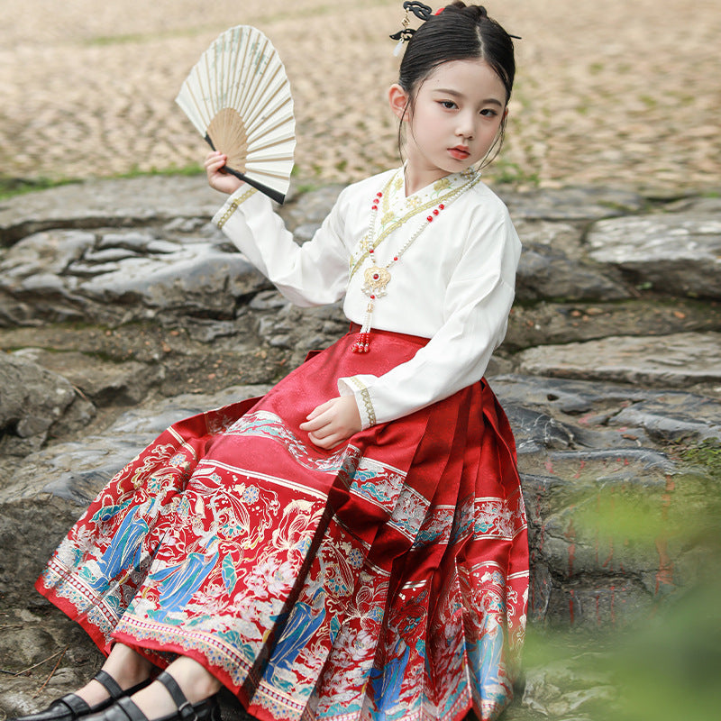 A model wearing a big red hanfu mamianqun outfit with gold embroidery and a matching headpiece.