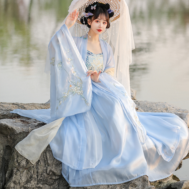 A female model wears blue traditional Hanfu and holds an oil umbrella, like a fairy descending from heaven